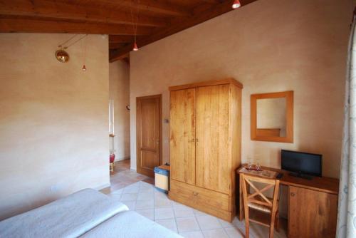 a bedroom with a bed and a cabinet and a television at Garni Viggiona in Trarego