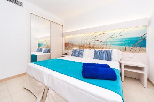 a bedroom with a large bed with a painting on the wall at Apartamentos Globales Lord Nelson in Santo Tomás