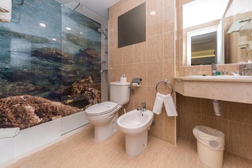 a bathroom with a toilet and a sink and a shower at Apartamentos Globales Lord Nelson in Santo Tomás