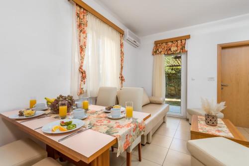 a living room with a dining table and a couch at Villas Rab Banjol in Rab