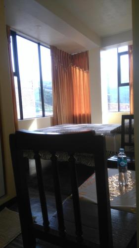 a room with a table and two windows at Hostal Inca in San Pedro