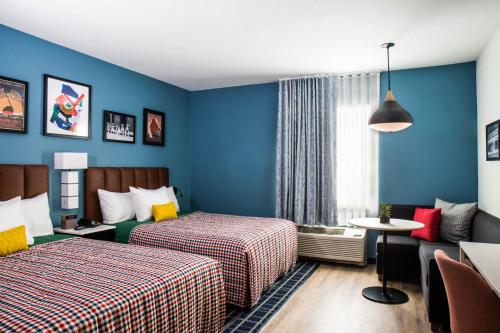 ein Hotelzimmer mit 2 Betten und einem Tisch in der Unterkunft Uptown Suites Extended Stay Austin TX - Round Rock in Austin
