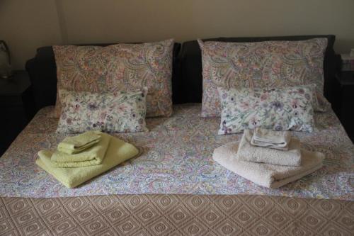 1 cama con 2 toallas y almohadas en Quiet spacious apartment in Nafplio, en Nauplia