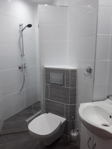 a white bathroom with a toilet and a sink at CBC Pokoje Hotelowe in Starogard Gdański