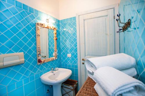 ein blaues Badezimmer mit einem Waschbecken und einem Spiegel in der Unterkunft Appartamento Mare Olbia – Murta Maria in Olbia