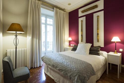 1 dormitorio con paredes moradas, 1 cama y 1 silla en Veoapartment Florentin 1-1, en Sevilla