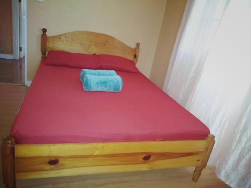 a bed with a wooden frame with a red mattress at Koinonia Retreat CenteR in Baguio