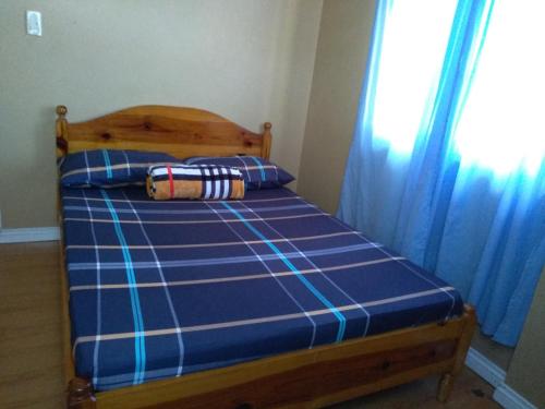 a bed in a bedroom with a blue bedsheet and a window at Koinonia Retreat CenteR in Baguio