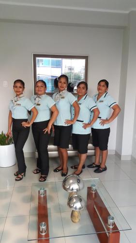PichanakiにあるTerraza Apart Hotelの制服を着た女性たちが写真を撮るためにポーズをとっている