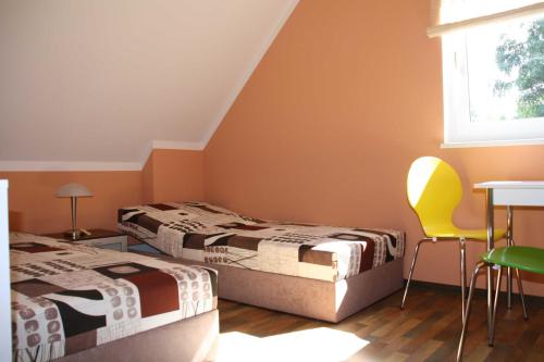 2 camas en una habitación con mesa y sillas en Haus Ostseekueste en Ostseebad Karlshagen