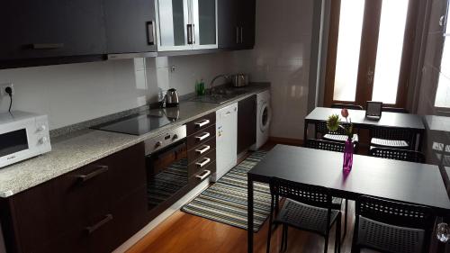 a small kitchen with a table and a microwave at Cool Guesthouse in Porto
