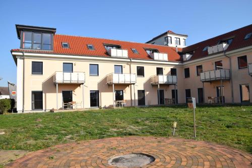 a large building with a grass field in front of it at Panoramawohnung in Peenemünde