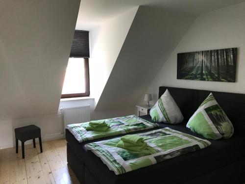 a bedroom with a black couch and a bed at Harzer Ferienlodge in Wernigerode