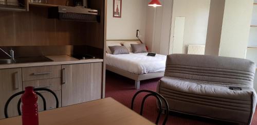 une chambre avec une cuisine et une chambre avec un lit dans l'établissement Résidence Wilson, à Le Mont-Dore
