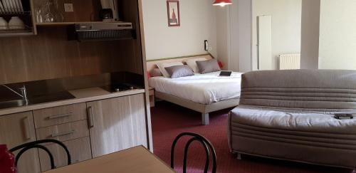 Habitación pequeña con cama y cocina con sofá en Résidence Wilson, en Le Mont-Dore