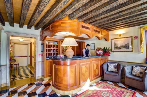 a man standing at a bar in a room at Hotel Antiche Figure in Venice