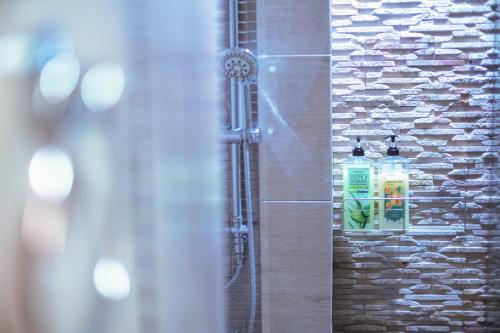 a shower in a bathroom with a soap dispenser at ARMO Nimman in Chiang Mai
