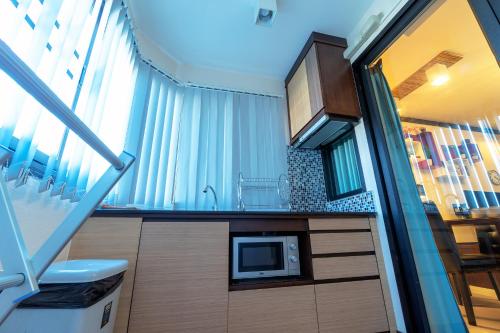a small kitchen with a microwave on a counter at ARMO Nimman in Chiang Mai