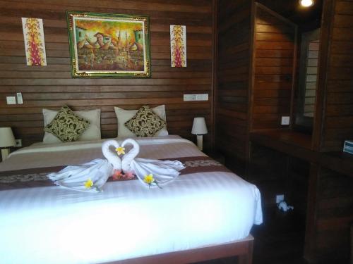 a bedroom with two beds with white dresses on them at Gatri Hut in Nusa Lembongan