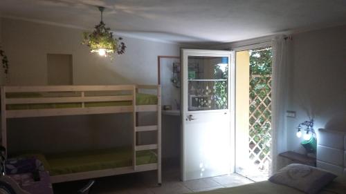 a bedroom with a bunk bed and a door to a room at casa di campagna dal pozzo in Sorso