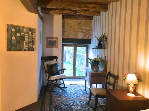 a living room with a table and chairs and a window at Maison La Mouline in Groléjac