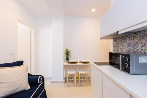 a small kitchen with a couch and a counter top at Georgioupolis Plaza Suites in Georgioupolis