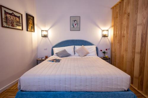 a bedroom with a large bed with a blue headboard at Amazing Trevi Fountain in Rome
