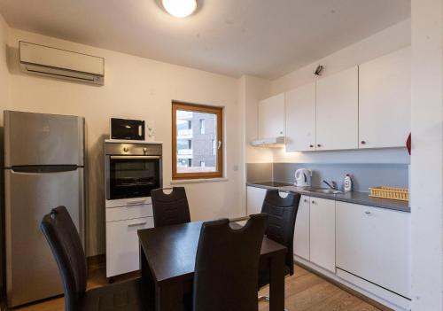 uma cozinha com uma mesa e cadeiras e um frigorífico em Apartment-Hotel Vila Petrovic-Becici em Budva