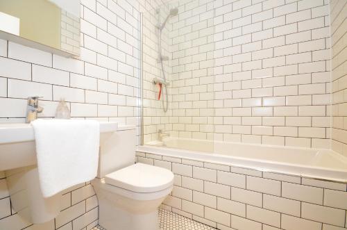 ヨークにあるThe Mews - 2 Bedroom Luxury, Spacious House With Free Parkingの白いバスルーム(トイレ、バスタブ付)