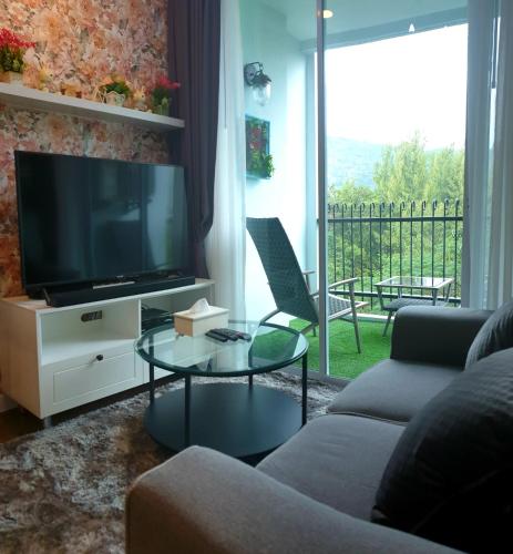 a living room with a couch and a tv at The Courtyard Khaoyai in Mu Si