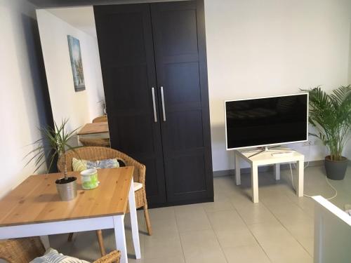 a living room with a television and a table with a table sidx sidx at Ferienwohnung Stricker in Birken-Honigsessen