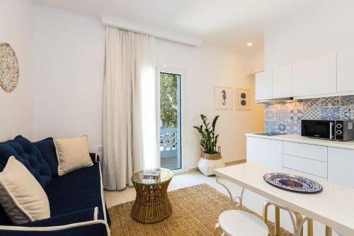salon z niebieską kanapą i kuchnią w obiekcie Georgioupolis Plaza Suites w mieście Georgioupolis