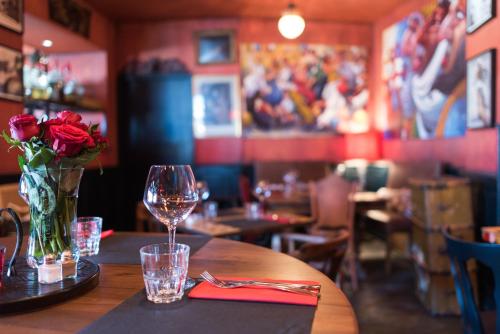 une table dans un restaurant avec un vase de roses dans l'établissement Le Loft du Cargo, à Locmiquélic