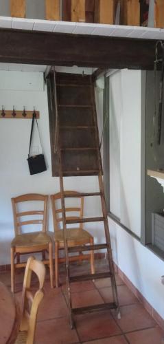 a ladder sitting next to two chairs and a table at Sur Un Petit Nuage in Roubion
