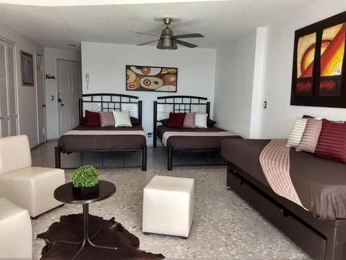 - une chambre avec deux lits, un canapé et une table dans l'établissement SUITE SELECT TORRES GEMELAS, à Acapulco