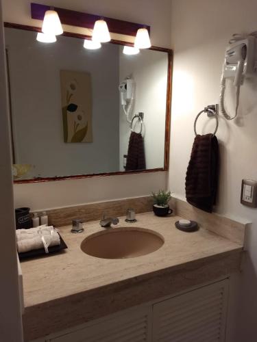 a bathroom with a sink and a large mirror at SUITE SELECT TORRES GEMELAS in Acapulco