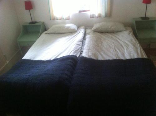 a large bed in a bedroom with two pillows on it at Änggårde B&B in Huse