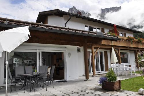 a house with a patio with a table and chairs at Haus Erli in Mittenwald