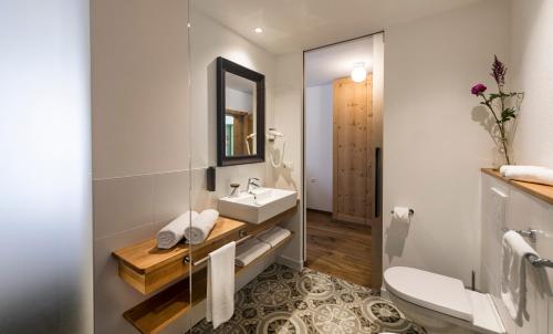 ein Bad mit einem Waschbecken und einem Spiegel in der Unterkunft Hotel Spanglwirt in Sand in Taufers