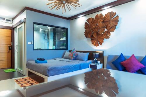 a bedroom with a bed with blue walls and colorful pillows at ARMO Nimman in Chiang Mai