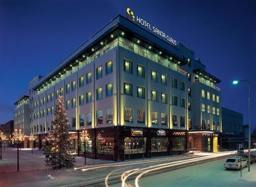 um grande edifício com uma árvore de Natal em frente em Santa's Hotel Santa Claus em Rovaniemi