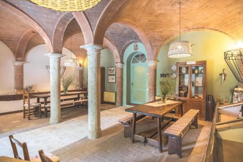 a dining room with a table and chairs in a building at Agriturismo diffuso Tenuta Armaiolo - widespread farmhouse in Rapolano Terme