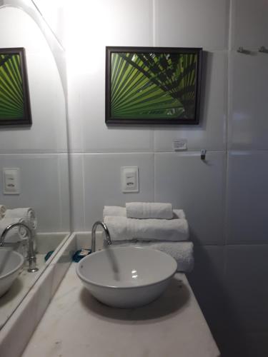 a bathroom with a sink and two sinks and towels at Pousada Berro do Jeguy in Pipa