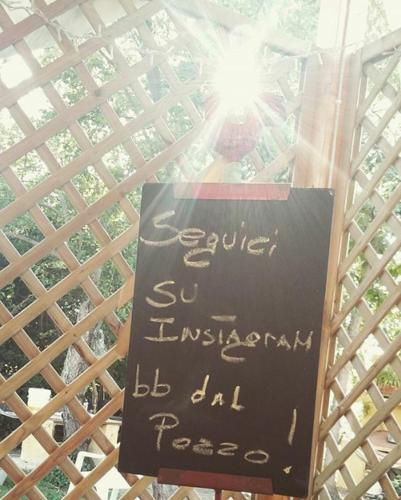 a sign on a pole with a sign for a restaurant at casa di campagna dal pozzo in Sorso