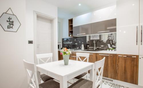 a white kitchen with a white table and chairs at Casablanca apartment in Belgrade