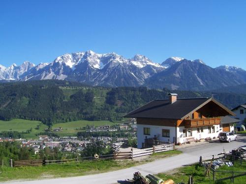 a house with a mountain range in the background at Pension Spreitzhof & Appartement Royer in Schladming