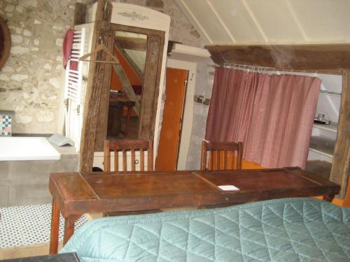 Zimmer mit einem Holztisch und einem Spiegel in der Unterkunft Chambre du Toucan in Misy-sur-Yonne