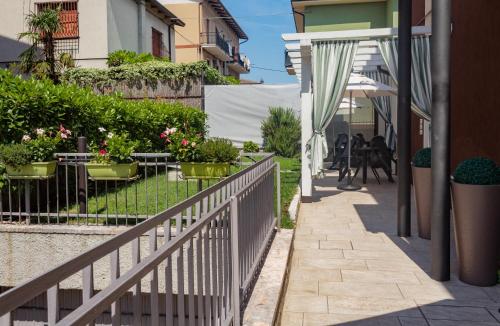 una acera con una valla, mesas y sillas en Blau Vacanze, en Peschiera del Garda
