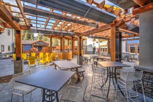 an outdoor patio with tables and chairs and a bar at Canalta Lodge in Banff