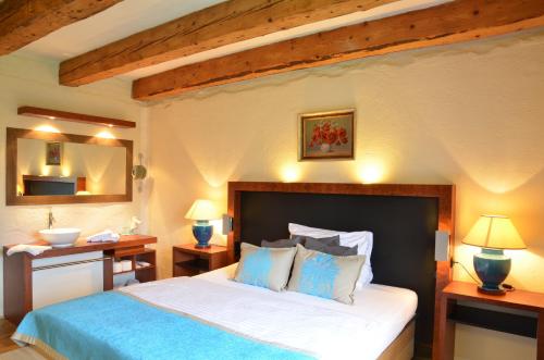 a bedroom with a large bed with blue and white pillows at Welness penzion Modrý jelen in Lipno nad Vltavou